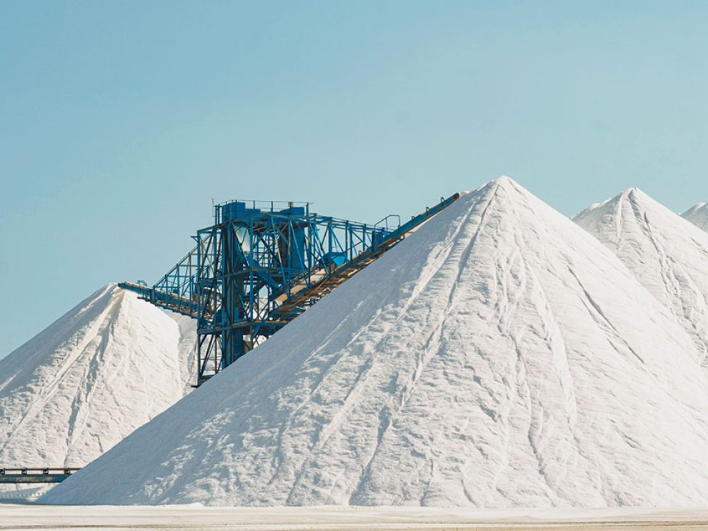 Weiße Berge aus Salz für den Streusalz-Frühbezug vor hellblauem Himmel